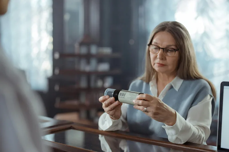 Woman reading product ingredient label carefully